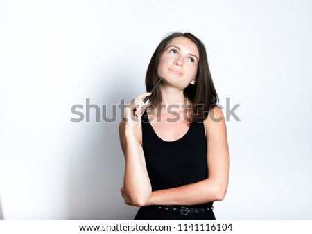 portrait of a beautiful young woman has a good idea, isolated studio photo on a gray background