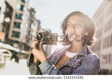 Woman with retro camera in the city