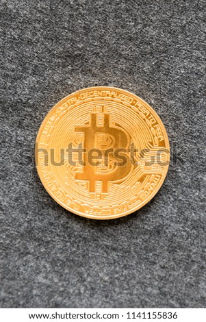 Golden bitcoin on grey background. Bitcoin is a modern way of exchange and this crypto currency is a convenient means of payment in the financial and web markets. vertical photo.