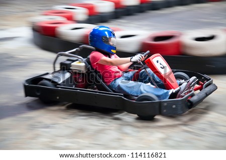 Indoor karting race (rushing kart and safety barriers) Royalty-Free Stock Photo #114116821