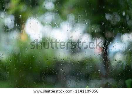Blur background of raindrops on window and green