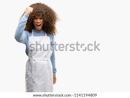 African american shop owner woman wearing an apron irritated and angry expressing negative emotion, annoyed with someone