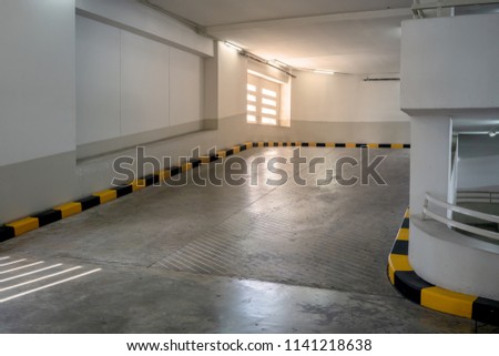 Concrete road and ramp with yellow and black curb in building