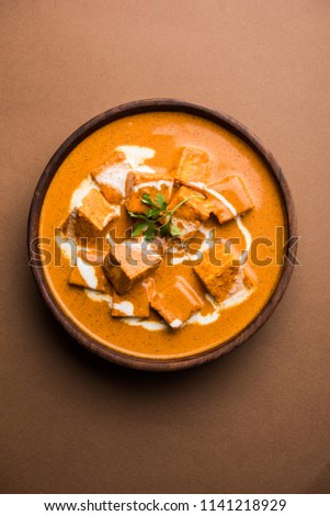 Paneer Butter Masala also known as Panir  makhani or makhanwala. served in a ceramic or terracotta bowl with fresh cream and coriander. Isolated over colourful moody background. selective focus
 Royalty-Free Stock Photo #1141218929