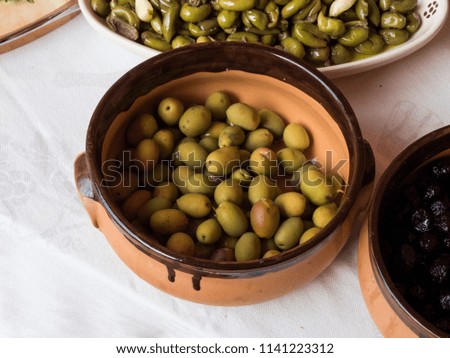 Green olives in a ceramic bowl. Top view.