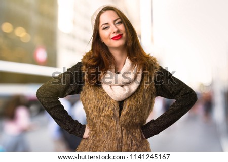 Happy girl with winter clothes on unfocused background