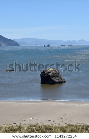 Sandy beach with large rocks in the surf. 