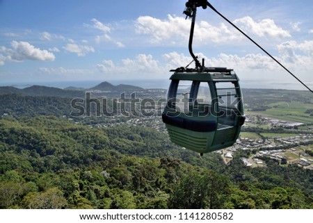 The cable car zips through the tropical rainforest of Cairns, in Northern Queensland, Australia. Royalty-Free Stock Photo #1141280582