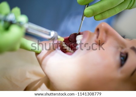 Dentist check up and repair tooth of young girl,injection
