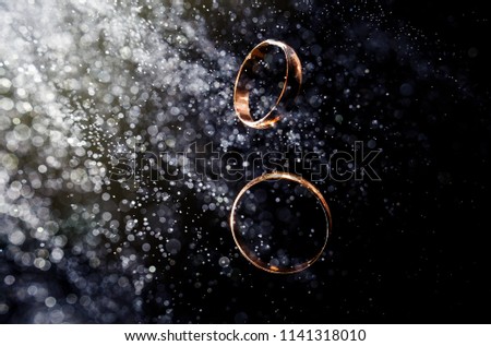 Wedding rings on black background with bokeh effects