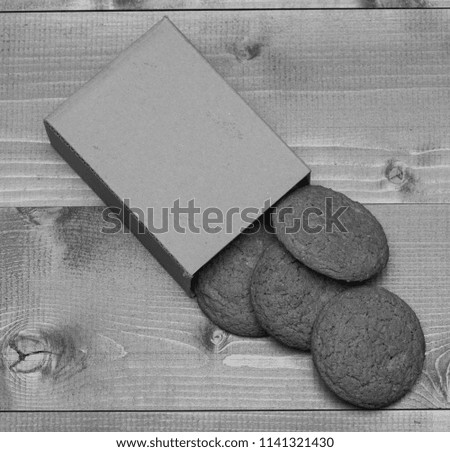 Cookies in carton box on grey wooden background. Homemade dessert concept. Sweet bakery and delicious snack. Oatmeal biscuits as tasty pastry for present.
