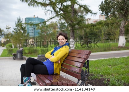 Portrait of a girl. The girl is sitting on a park bench
