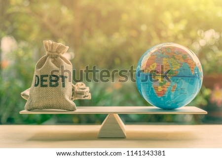 World or global / national debt crisis or imbalance concept : Debt bag and world globe on a balance scale, depicts the government's fiscal profligacy, excessive expenditure or increase public spending Royalty-Free Stock Photo #1141343381