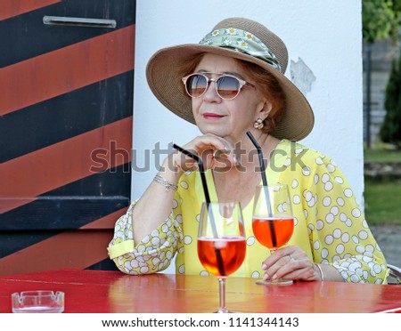 Woman in a hat sits in a cafe.