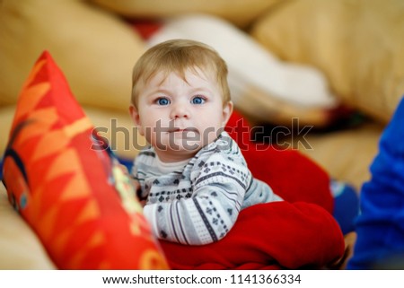 Little kid boy hugging with newborn baby girl, cute sister. Brother on background