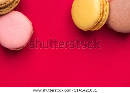 Variety of Multicolored Pink Green Yellow Brown Mocha Coffee Macarons Scattered on Blue Background Upper Border. Bakery Confectionery Pastry Shop Poster Banner Design Template