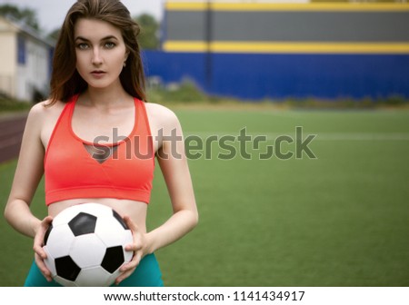 Woman football player in top and shorts on the football field