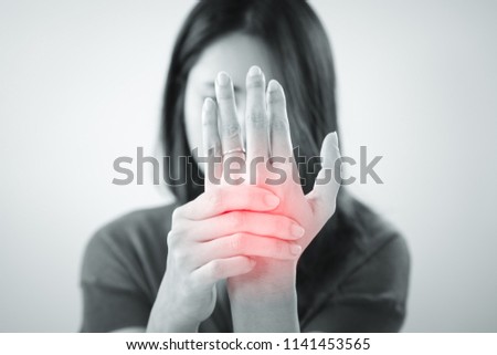 Young asian woman suffering from pain in palms. Female massaging her painful hand from symptoms of Peripheral Neuropathy. Pain and numbness in fingertips and palms. Health care and physical concept.