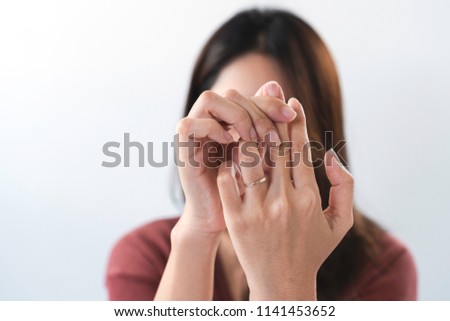 Young asian woman suffering from pain in fingertips. Female massaging painful hand from symptoms of Peripheral Neuropathy. Pain and numbness in fingertips and palms. Health care and physical concept.