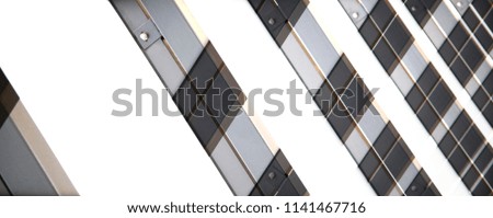 Abstract modern architecture in black and white. Low angle photo of office building exterior featuring frames of aluminum structural glazing. Geometric background with diagonal parallel lines.