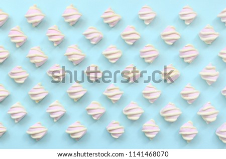 Colorful marshmallow laid out on blue paper background. pastel creative textured pattern. minimal