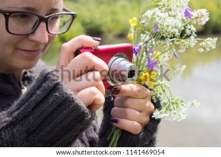 young woman takes pictures of nature near the river. girl photographer with retro camera