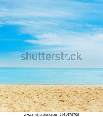 sand on the beach. sea on horizon and blue sky with clouds. soft focus on bottom of picture