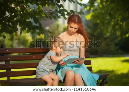 Mom teaches the child to use the tablet