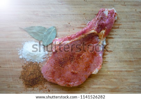 Bone In Rib Eye row Steak on pieces of salt on a wooden board. Stock image