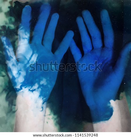 hands under the water with blue stains