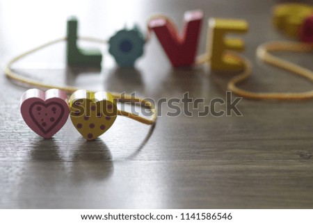 LOVE letter with heart. A word of love tied up on strings with wooden background. Valentine's Day, selective focus.