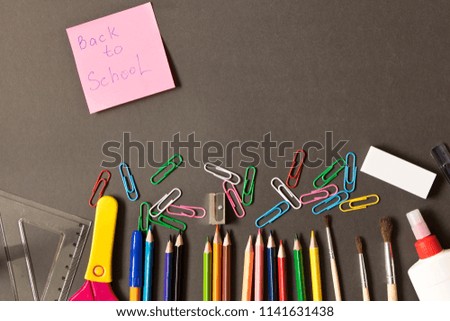 Various school supplies on the blackboard background . The concept of education. With empty space for text.