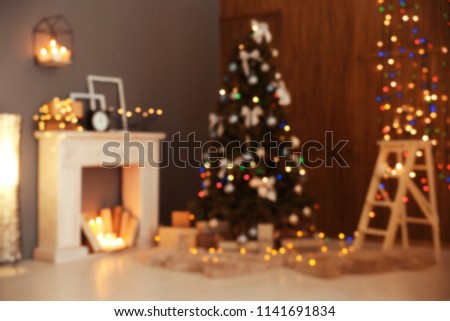 Blurred stylish room interior with Christmas tree and decorative fireplace