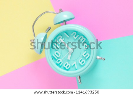 alarm clock , 8 O'Clock in the morning on pastel color background in copy space. bright color style    Royalty-Free Stock Photo #1141693250