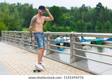 Athletic guy on a skateboard in the park. A man is riding a skateboard