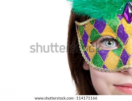 A young girl in a gold, purple and green mardi gras mask with copy space