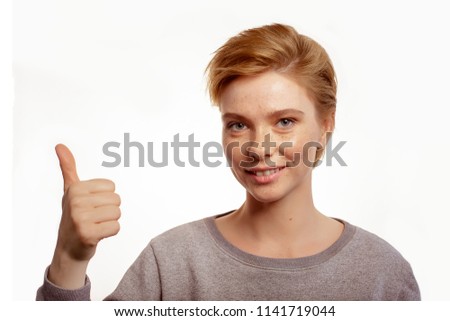 Portrait of a laughing woman showing thumbs up isolated on a white background