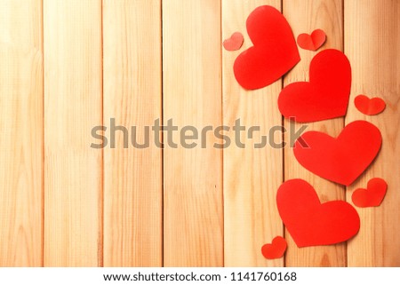 Red paper hearts on wooden background