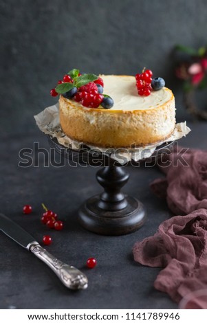 Homemade cheesecake with fresh berries on a dark wooden stand. New York cheesecake. Homemade cake.