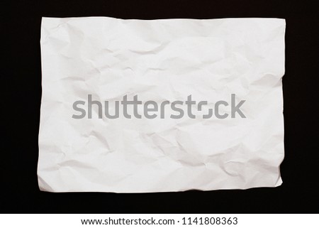 White wrinkled paper on a black background. Texture. Background.
