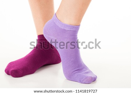 Side view of beautiful human foot dressed in new nice and soft natural cotton fabric blank sock isolated on abstract white background. Wearing and sport clothes concept. Detailed closeup studio shot