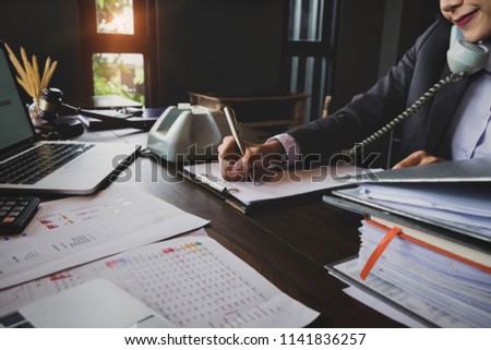 Economist and accountant, female working with document, computer laptop, calculator and using phone contact to customer in office.