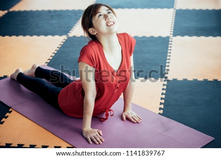Asian girl playing with a yoga school at yoga class in early morning. Lifestyle and healty concept.