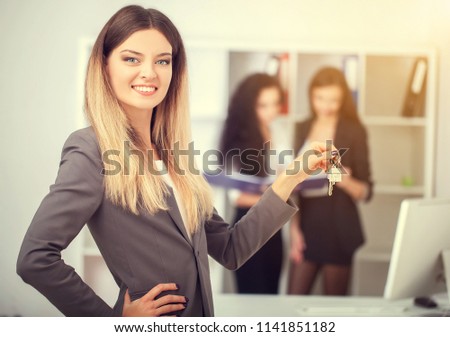 business, real estate and banking concept - smiling businesswoman with house keys