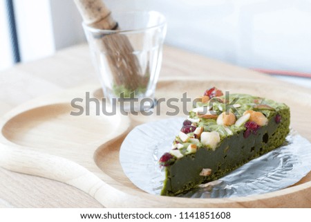 The slice of green tea cake topping with almond and nut 