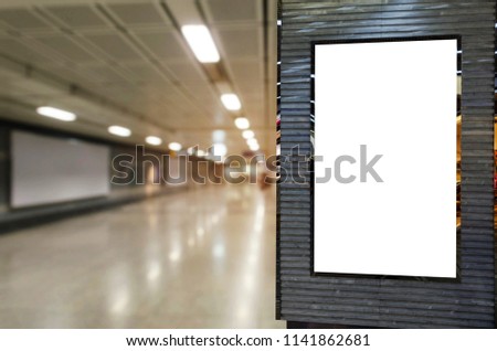 blank billboard or advertising light box for your text message or media content with blurred image of walkway in subway at railway station, transportation, commercial and marketing concept