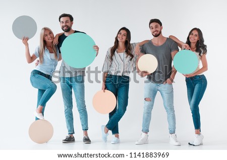 Group of young people isolated on white background. Attractive youth standing together with empty circle advertisement boards.