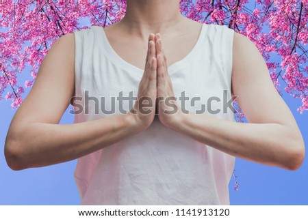 The hands of a young woman who symbolizes religious beliefs and God blessings to meet business success and invest in a beautiful natural on a cherry blossom background.concept of Faith in God