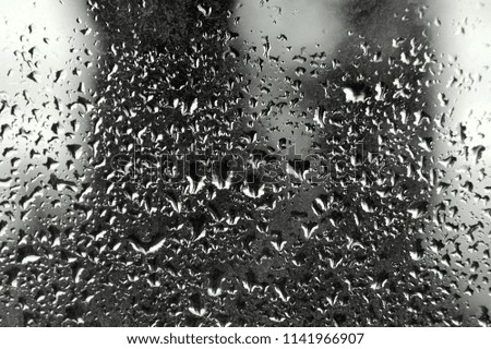 drops on the glass, it rains, black and white background. window water Royalty-Free Stock Photo #1141966907
