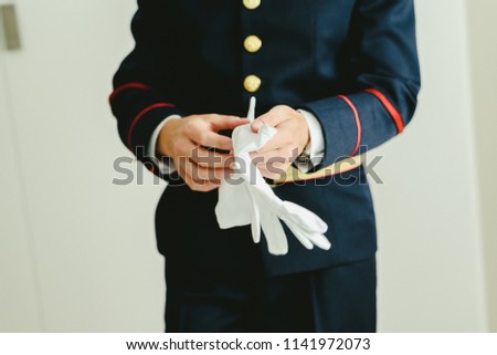 Military man hands putting on some elegant white gloves.